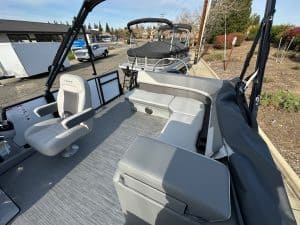 Modern boat interior with comfortable seating, steering console, and open deck space.