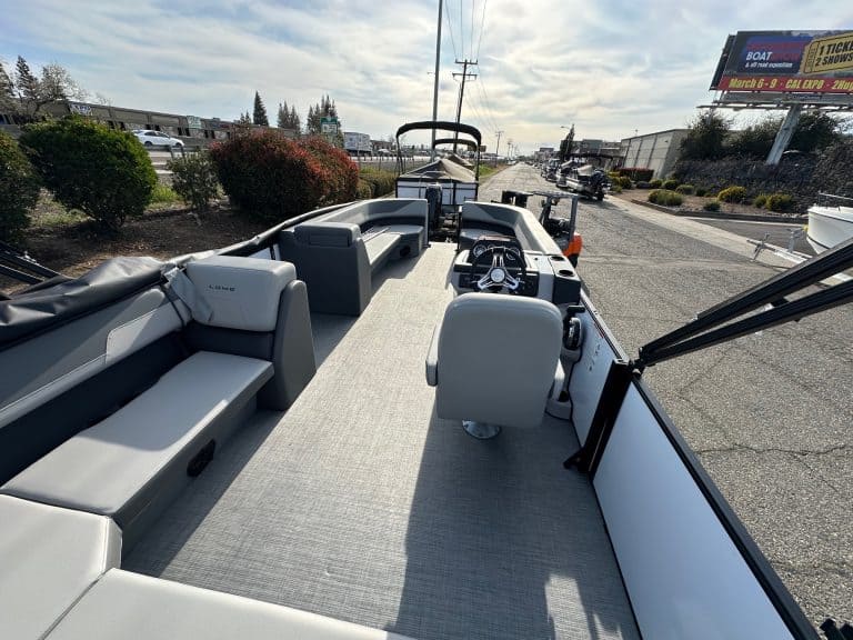 Boat interior with seating and steering console at a dealership.