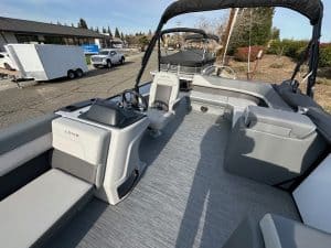 Pontoon boat interior with comfortable seating, steering console, and open deck for leisure and wate.