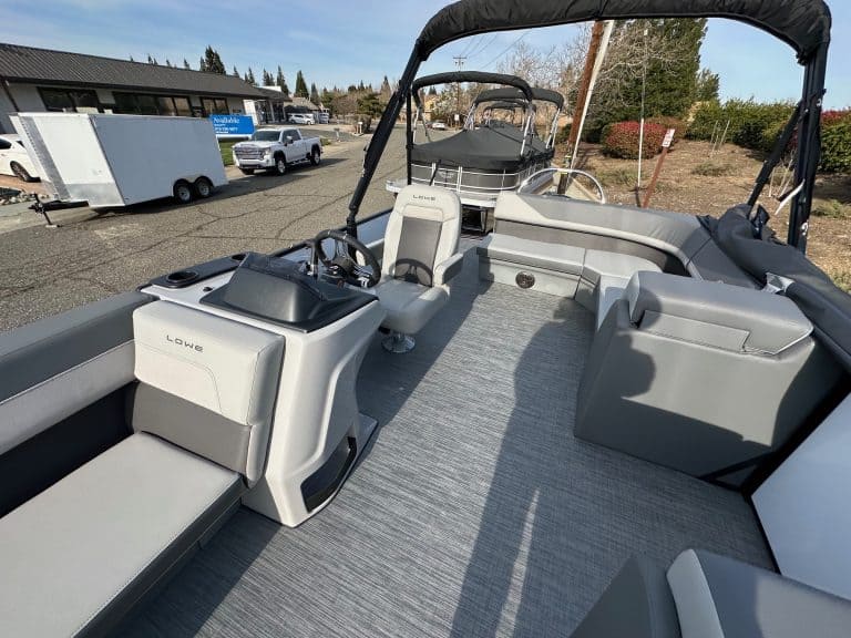 Pontoon boat interior with comfortable seating, steering console, and open deck for leisure and wate.