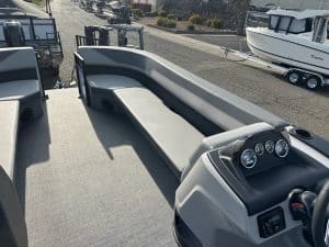 Modern pontoon boat with spacious seating and dashboard, ideal for leisure and fishing.