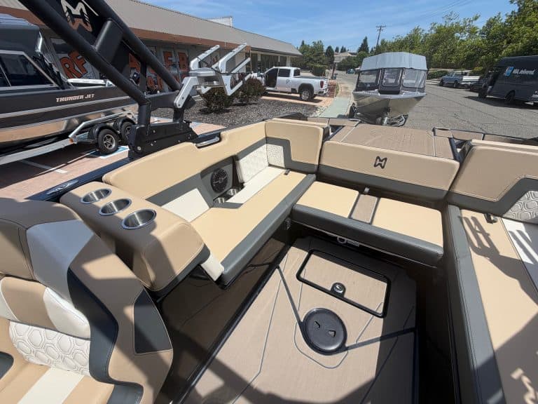 Luxury boat cockpit with beige and black seating, control panel, and storage compartments.