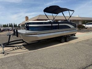 Pontoon boat on trailer with canopy, ideal for boating and outdoor recreation.
