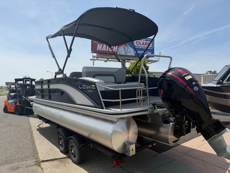 Pontoon boat with outboard motor on trailer for easy transport and storage.