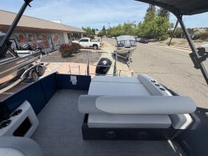 Boat deck with seating and outboard motor, outdoor scene at marina.