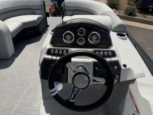 Marine boat dashboard with steering wheel and instrument gauges for optimal navigation.
