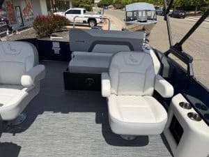 Boat interior with white cushioned seats and dashboard, showcasing modern design and comfort.