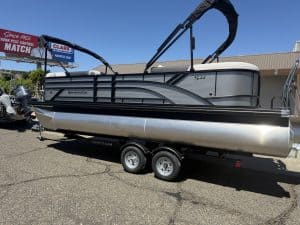 Modern pontoon boat with canopy and dual-axle trailer for outdoor water activities.