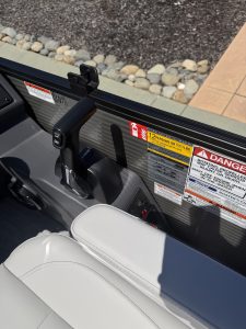 Close-up of boat console with safety labels and electronic controls for marine navigation.