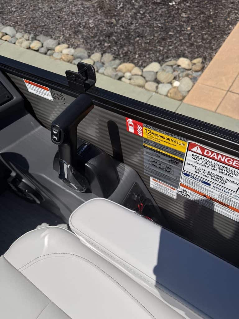 Close-up of boat console with safety labels and electronic controls for marine navigation.