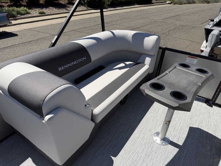 Bennington pontoon boat with comfortable seating and built-in table for outdoor relaxation.