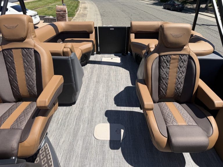 Comfortable brown and black pontoon boat seats with armrests and headrests.