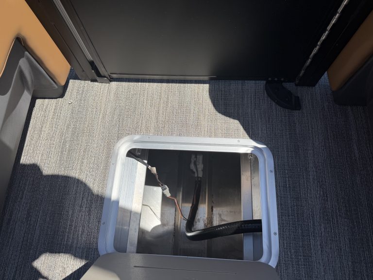 Storage compartment for boat engine access on Bennington M 23.
