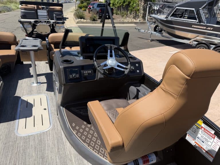 Boat console with steering wheel and seating on a pontoon boat.