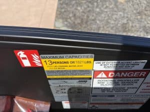 Close-up of Bennington M 23 boat with 250HP outboard motor and safety labels.