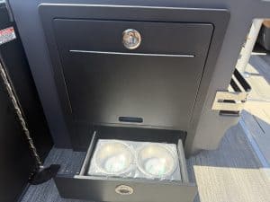 Boat storage compartment with built-in cup holders and lockable door.