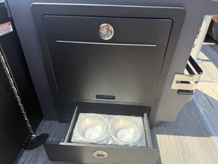 Boat storage compartment with built-in cup holders and lockable door.