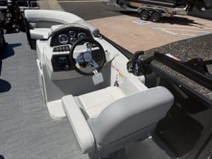 Boat cockpit with steering wheel and control panel, showcasing modern marine design.