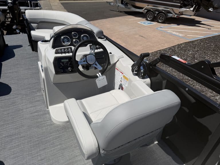 Boat cockpit with steering wheel and control panel, showcasing modern marine design.