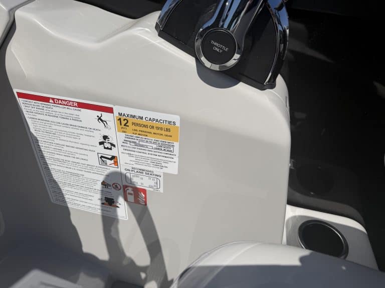 Fuel tank cap on a boat with safety and capacity labels visible.