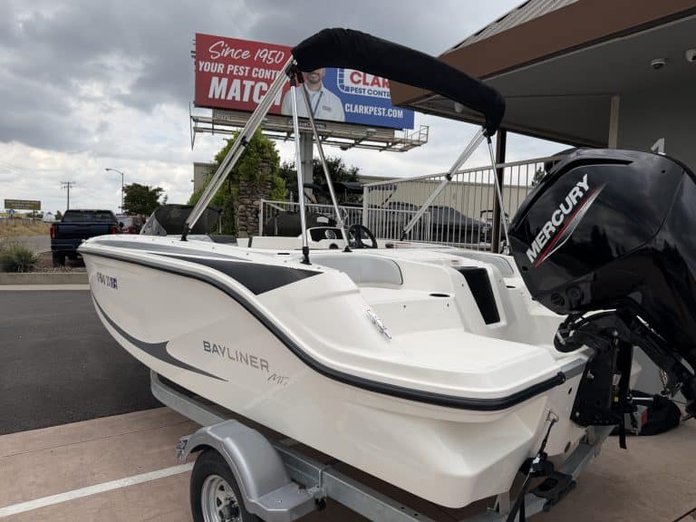 Boat with Mercury outboard motor at a dealership lot.