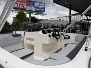 Boat cockpit with steering wheel and seating, outdoor marine vessel for leisure.
