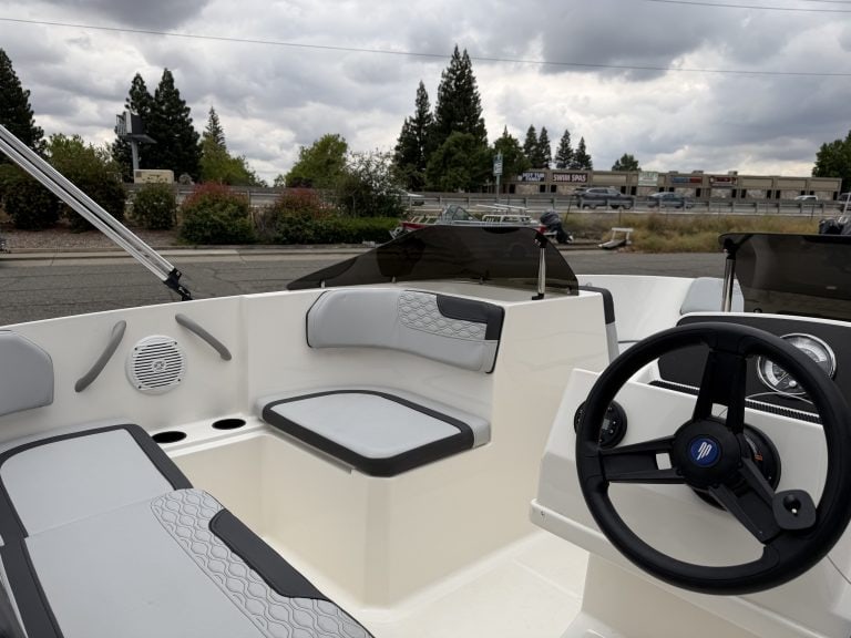 Boat cockpit with steering wheel and seating area.