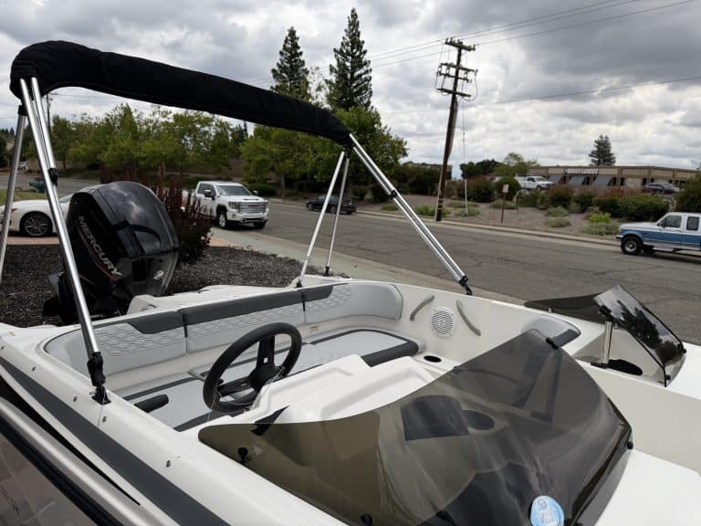 Opti boat with Bimini top, dashboard, and seating for recreational boating.