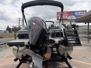 Pontoon boat with outboard motor, canopy, and safety rails for water fun and leisure activities.