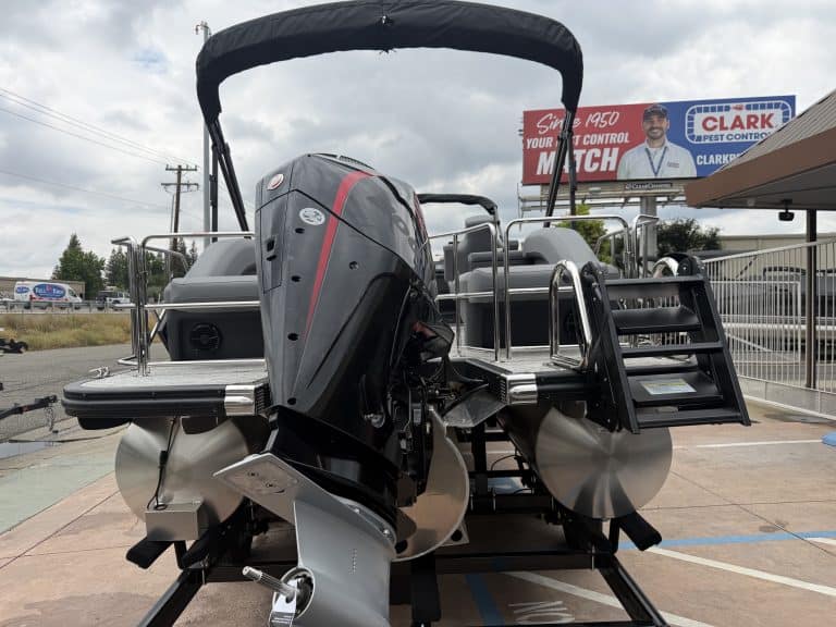 Pontoon boat with outboard motor, canopy, and safety rails for water fun and leisure activities.