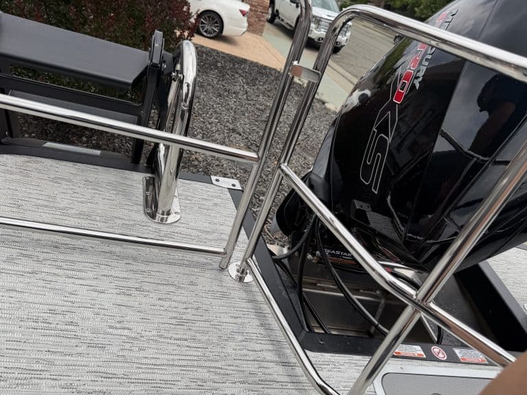 Marine boat platform with stainless steel railing and outboard motor.