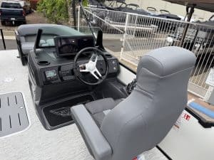 Close-up of a boat helm with navigation system and steering wheel for marine operation.