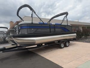 Pontoon boat with canopy on trailer, ready for water adventures. Perfect for leisure and family outi.