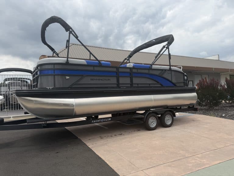 Pontoon boat with canopy and dual engines on trailer for easy transport.