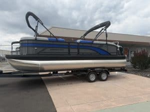 Modern pontoon boat on trailer, ready for water adventures, displayed outdoors.