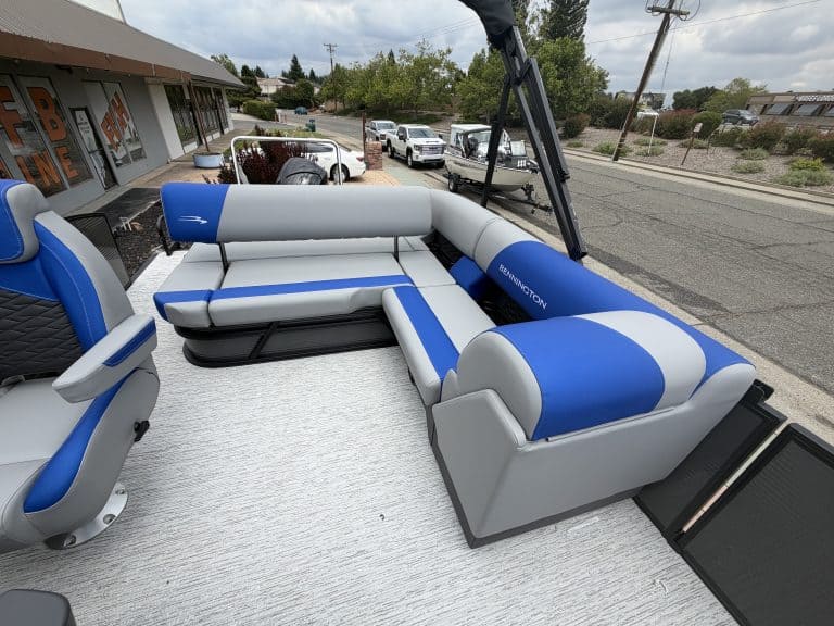 Pontoon boat with blue and gray seating for leisure and water activities.