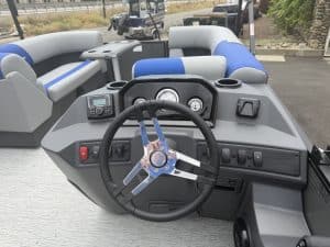 Boat steering console with modern controls and seating area.