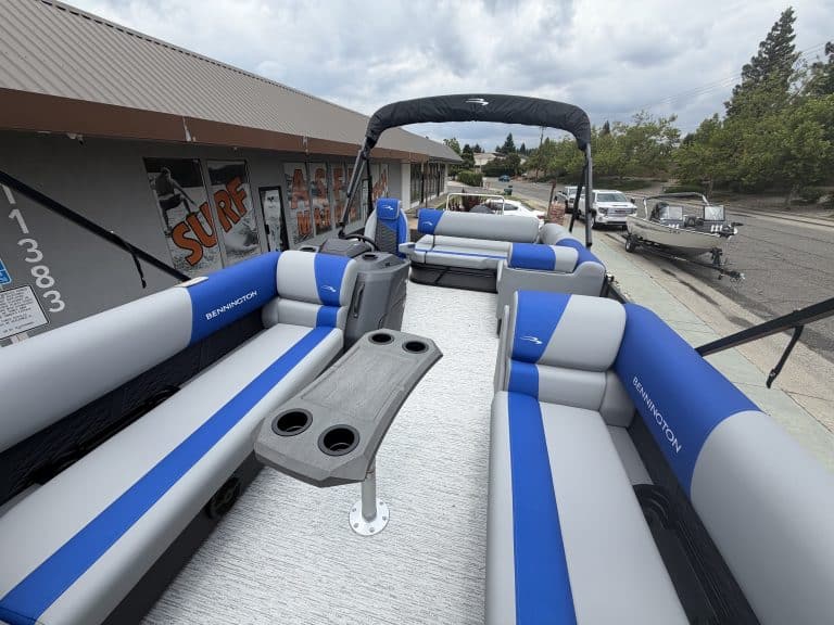 Pontoon boat with blue and white seating, ideal for water sports, family outings, and leisure activi.