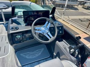 Boat control console with steering wheel and electronic displays for marine navigation.