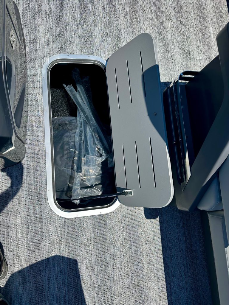 Marine trash bin with lid open on boat deck for waste disposal.