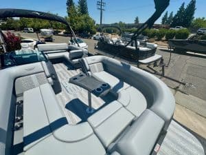 Luxury pontoon boat with seating and canopy at a marina.
