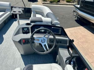 Luxury pontoon boat helm with modern controls and steering wheel for optimal navigation.