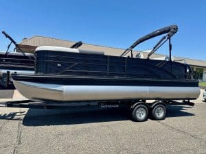 Modern black and silver pontoon boat on trailer at ASFB Marine dealership.