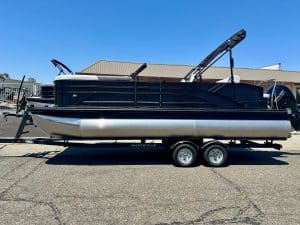 Modern black and silver pontoon boat with wakeboard towers on trailer.
