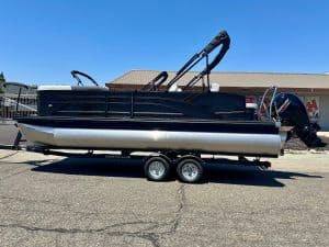 Pontoon boat on trailer, ready for water, ideal for leisure and fishing adventures.