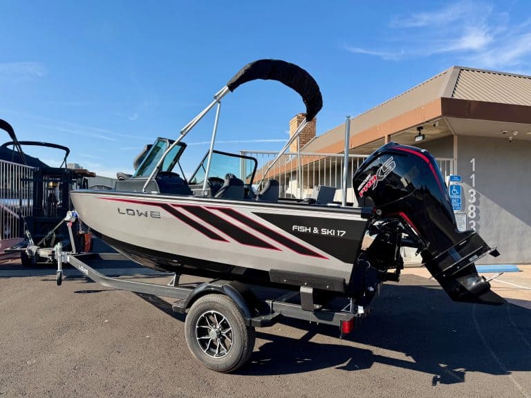 Fish and ski boat with outboard motor on trailer, ready for water adventures.