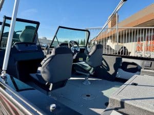 Boat interior with steering console and seating for fishing or leisure activities.