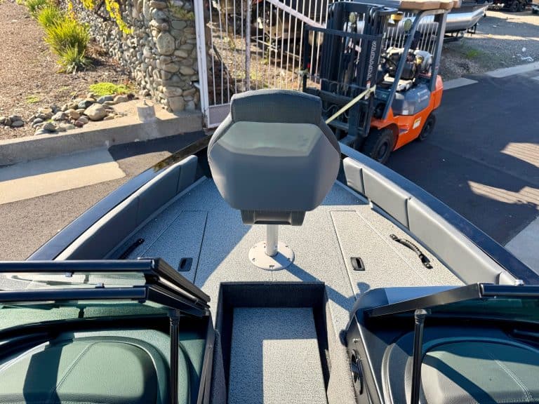 Recreational boat deck featuring seating, steering console, and storage compartments for boating adv.