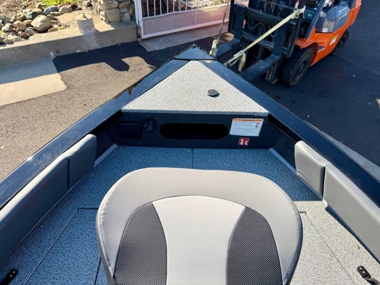 Boat interior with seating area and forklift in background for marine transport and boat customizati.