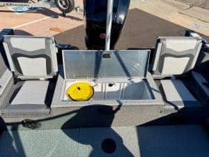 Boat storage compartment with seating and outboard motor in the background.